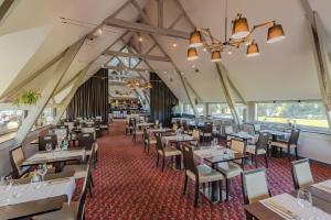 un comedor vacío con mesas y sillas en Saint Malo Golf Resort, en Le Tronchet