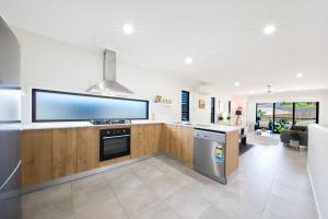 uma cozinha com uma grande televisão de ecrã plano na parede em Whitsunday Whisper Terrace - Townhouse Pets Airlie em Airlie Beach
