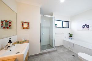 une salle de bain avec douche et lavabo dans l'établissement Whitsunday Whisper Terrace - Townhouse Pets Airlie, à Airlie Beach 7 autres photos