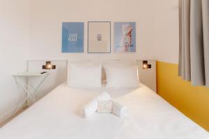 1 dormitorio con cama blanca y almohadas blancas en The People Caen en Caen