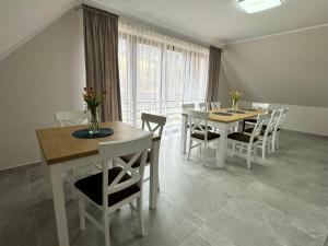 a dining room with two tables and chairs and a window at Willa Wioletta in Tylmanowa