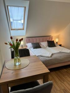 a bedroom with two beds and a table with a vase of flowers at Willa Wioletta in Tylmanowa