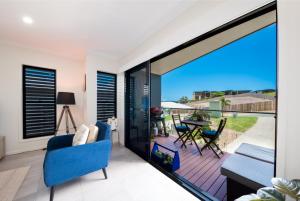sala de estar con una gran puerta corredera de cristal que da a un balcón en Whitsunday Whisper Terrace - Townhouse Pets Airlie, en Airlie Beach
