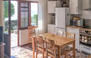 a kitchen with a wooden table and chairs in a kitchen at Beach Front Home In Gradac With House Sea View in Gradac