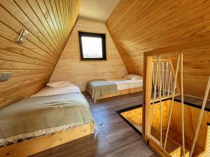 a room with two beds and a window in a cabin at OUTSCAPE l Cabaña Familiar en mejor sector de Cerro Castillo in Villa Cerro Castillo