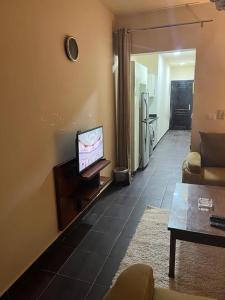 een woonkamer met een tv en een bank bij Appartment - Porto Sharm El Sheikh - Chalet 61205 B in Sharm El Sheikh