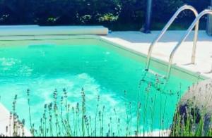 a swimming pool with blue water in a yard at Gîte de Juliana 4 personnes in Sundhouse