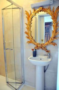 een badkamer met een wastafel, een spiegel en een douche bij The Sardinian Guesthouse (6 Bedrooms) in Cobh