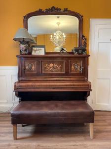 a piano sitting in a room with a mirror at The Sardinian Guesthouse (6 Bedrooms) in Cobh