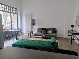 ein Wohnzimmer mit einem grünen Sofa und einem Tisch in der Unterkunft Loft nahe Schloss Charlottenburg in Berlin