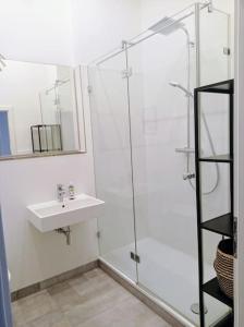 a white bathroom with a sink and a shower at Loft nahe Schloss Charlottenburg in Berlin