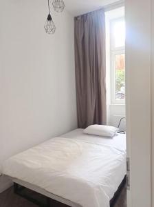 ein weißes Bett in einem Zimmer mit Fenster in der Unterkunft Loft nahe Schloss Charlottenburg in Berlin