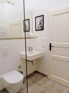 a white bathroom with a toilet and a sink at Loft nahe Schloss Charlottenburg in Berlin