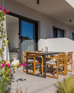 Une table à manger et des chaises sont disponibles sur la terrasse. dans l'établissement The 8 Suites, à Polychrono
