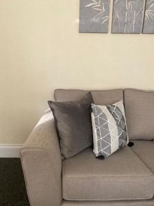 a couch with two pillows on it in a living room at Chepstow House (5 BR with FREE on-steet parking) in Newport