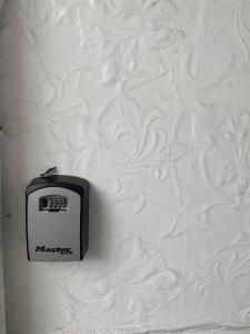een klok op een witte muur met een klok erop bij Chepstow House (5 BR with FREE on-steet parking) in Newport