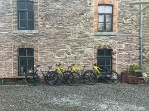 a group of bikes parked in front of a brick building at B&B Ferme1883 in Lierneux