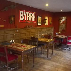 B&B Ferme1883 في Lierneux: مطعم بطاولات وكراسي وعلامة على الحائط