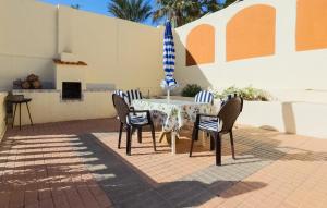 パロス岬にあるStunning Home In Cabo De Palos With Wifiのテーブル(椅子付)、青と白の傘