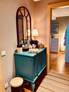 een blauwe dressoir in een kamer met een spiegel bij Guest House in Luxemburg