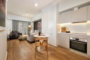 eine Küche und ein Wohnzimmer mit einem Tisch und einem Sofa in der Unterkunft Viola Comfort Suite in Athen