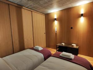 2 Betten in einem Zimmer mit Holzwänden in der Unterkunft Fervença Apartments in Vila Nova de Gaia