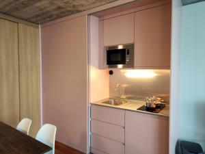 una cocina con fregadero y microondas en Fervença Apartments, en Vila Nova de Gaia 80 fotos más