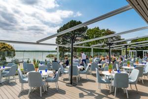 a restaurant with tables and chairs and a view of the water at Harbour Hotel & Spa Christchurch in Christchurch