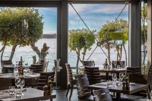 a restaurant with tables and chairs and a view of the water at Harbour Hotel & Spa Christchurch in Christchurch