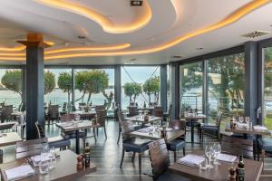a restaurant with tables and chairs and windows at Harbour Hotel & Spa Christchurch in Christchurch
