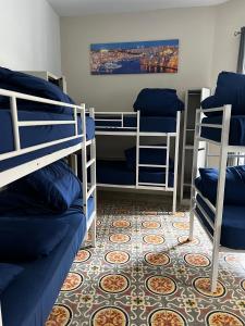 a room with three bunk beds and a carpet at Bookarest Hostel Malta in St. Julianʼs