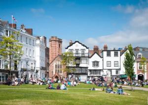 a group of people sitting on the grass in a park at City Centre Stylish Hideaway in Exeter