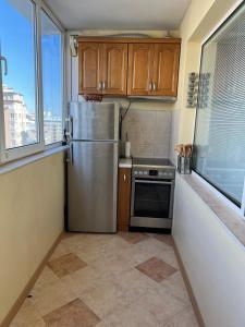 una cucina con frigorifero in acciaio inossidabile e piano cottura di Business Park Sofia Apartment a Sofia