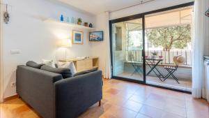 a living room with a couch and a sliding glass door at CANADELL BLOC B baixos 1ª in Calella de Palafrugell