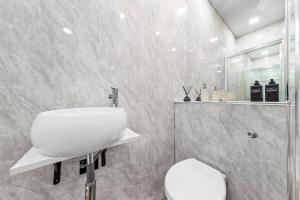 Baño blanco con aseo y lavamanos en Luxury Two Bedroom Flat right opposite to Harrods KB15 en Londres