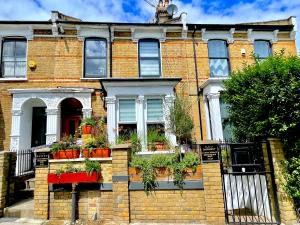 a brick house with potted plants in front of it at 1 Bedroom Flat with whirlpool bath in London