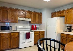 - une cuisine avec des placards en bois et un réfrigérateur blanc dans l'établissement Modern 2 Bed One Bath At West Side, à New York