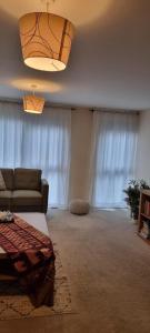 a living room with a couch and a chandelier at Stunning 2-Bed Apartment near Colindale Station in Hendon