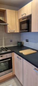 a kitchen with a stove and a microwave at Stunning 2-Bed Apartment near Colindale Station in Hendon