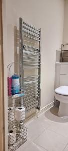 a bathroom with a toilet and a rack with towels at Stunning 2-Bed Apartment near Colindale Station in Hendon