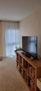 a living room with a flat screen tv on a book shelf at Stunning 2-Bed Apartment near Colindale Station in Hendon