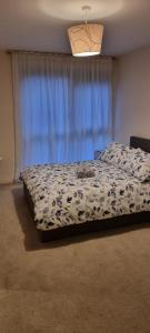 a bedroom with a bed with a cat laying on it at Stunning 2-Bed Apartment near Colindale Station in Hendon
