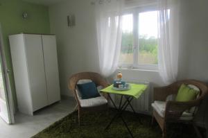 d'un salon avec une table, des chaises et une fenêtre. dans l'établissement Chambre 20m2 avec salle de bain privée dans maison en bois, à Lavaur