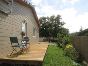 a wooden deck with two chairs and a table at Chambre 20m2 avec salle de bain privée dans maison en bois in Lavaur