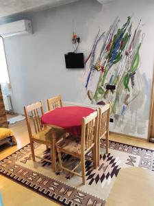 a dining room table with chairs and a red table at Rila Apartment in Samokov