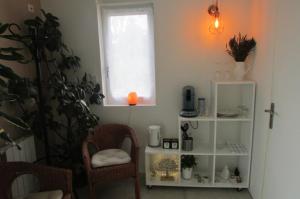 a living room with a chair and a window at Chambre 20m2 avec salle de bain privée dans maison en bois in Lavaur