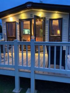 a small house with a fence on a porch at Beautiful Caravan With Decking At Hoburne Devon Bay, Ref 54058f in Paignton
