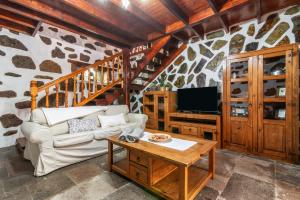 un soggiorno con divano e TV di El patio canario a Firgas