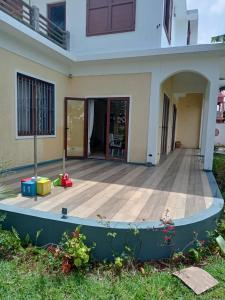 un porche de una casa con terraza de madera en Villa Benaglia, en Mahébourg