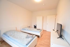 a bedroom with two beds and a tv at CoreRooms - Apartment Bochum Wattenscheid in Bochum